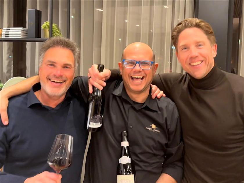 Drie leden lachen samen aan tafel